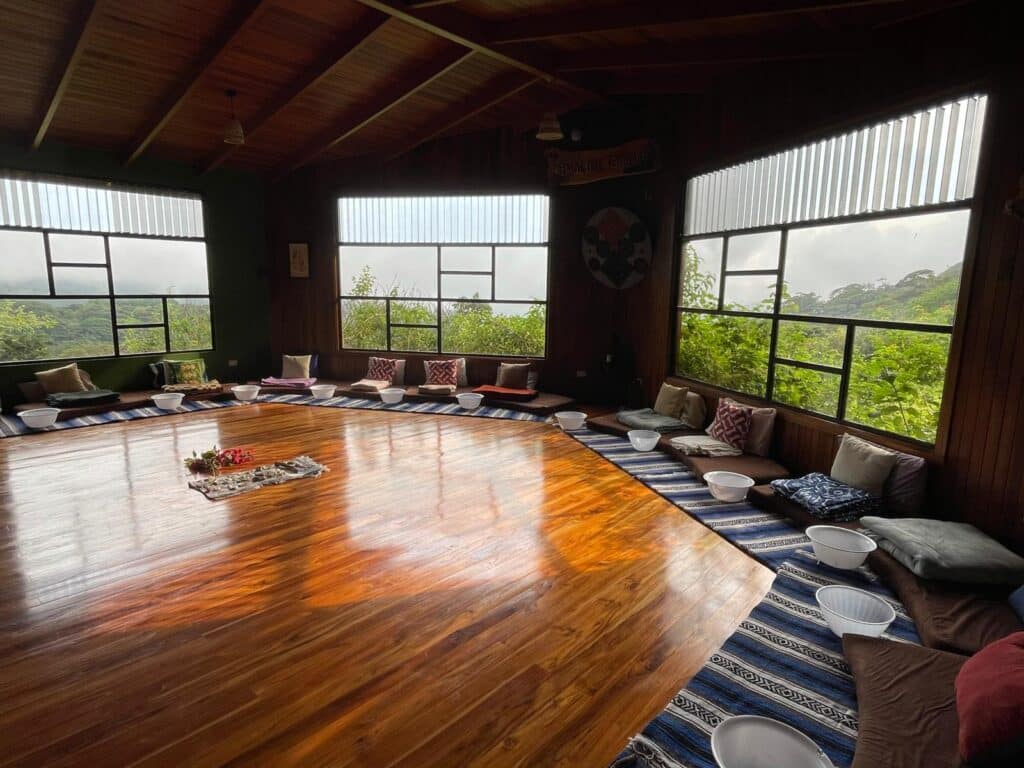 A wooden hall with windows onto the green hills